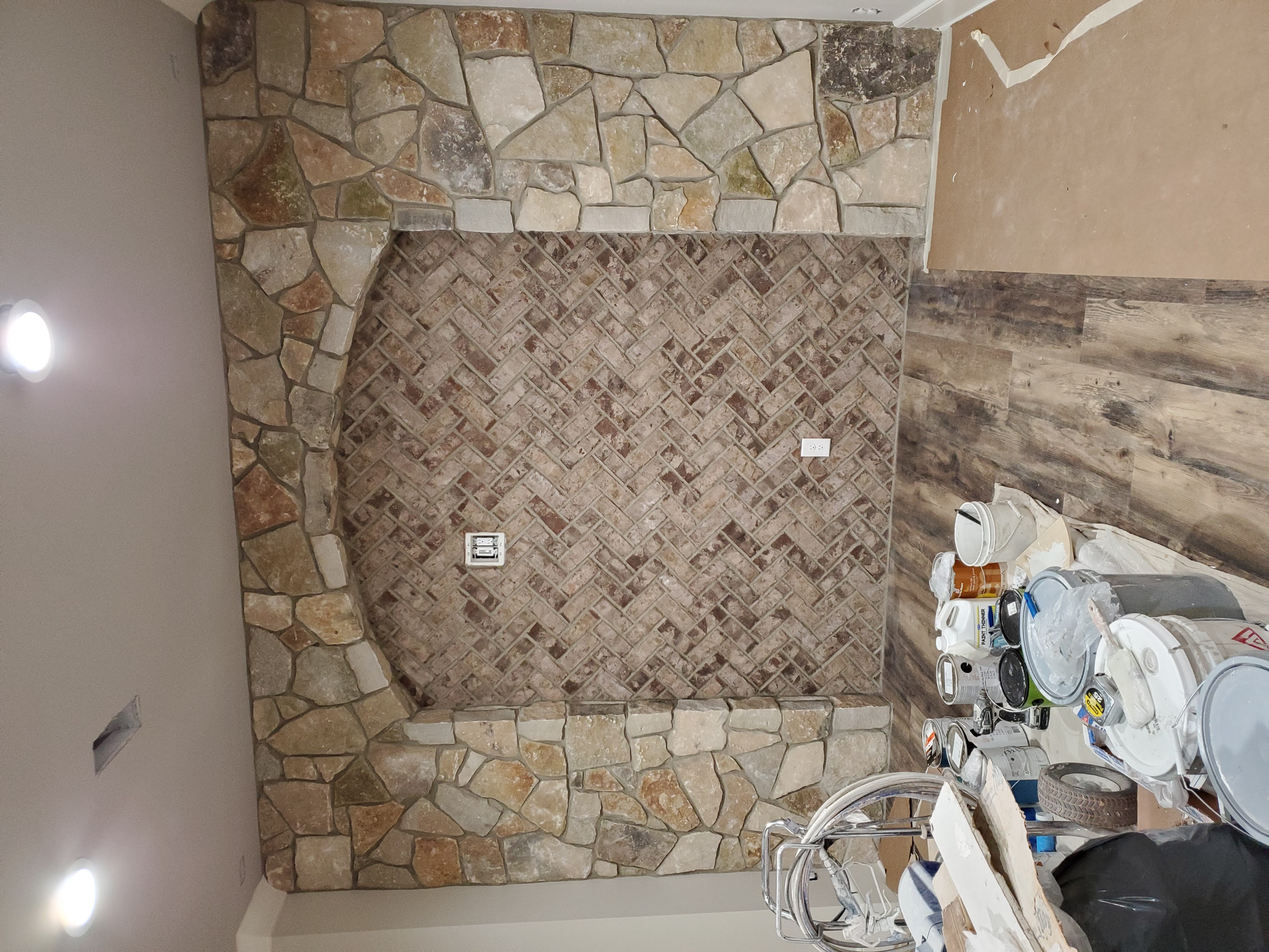 Brick and stone fireplace surround under construction by SD Masonry