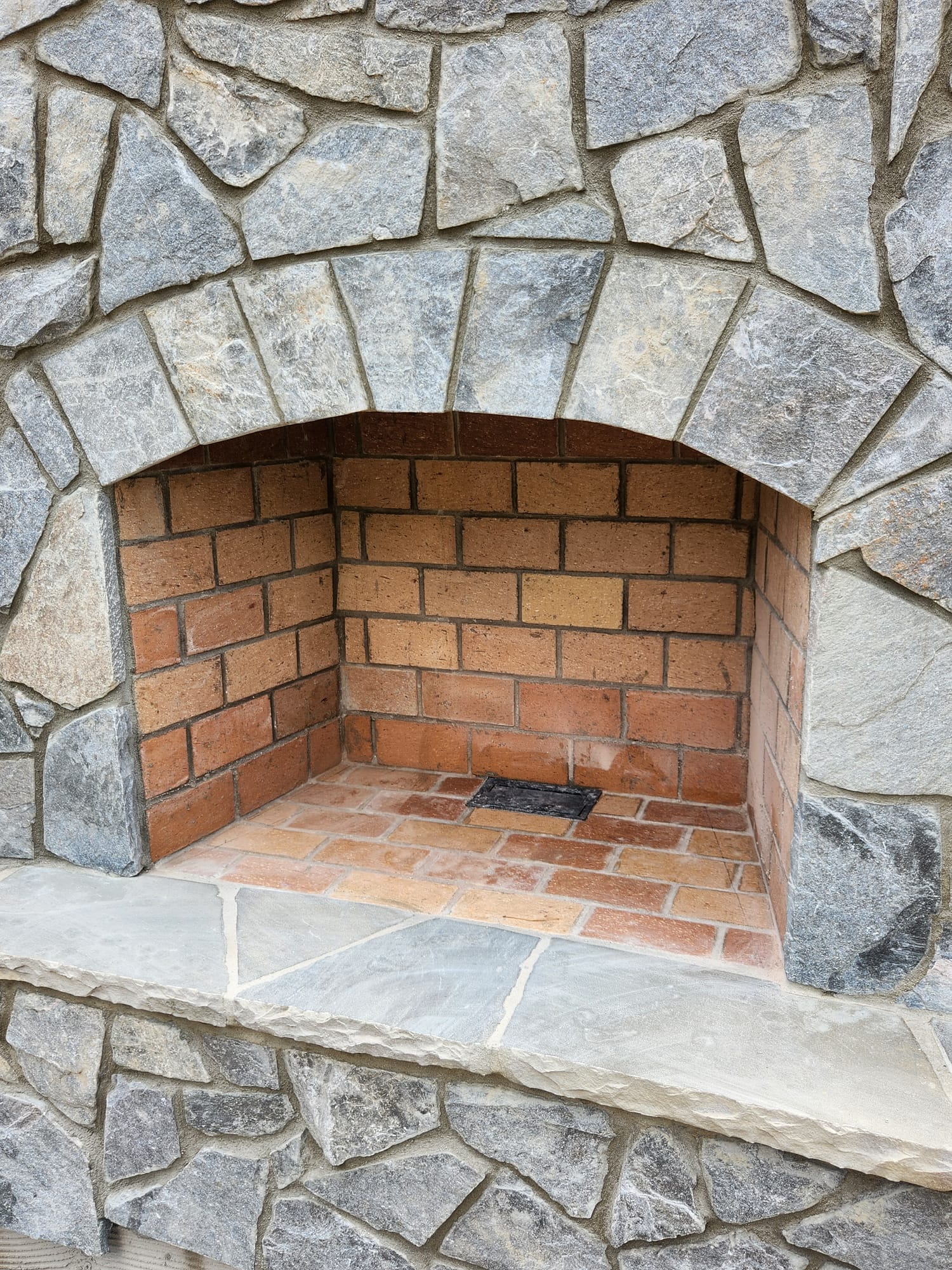Outdoor stone fireplace under construction by SD Masonry near Lake Norman